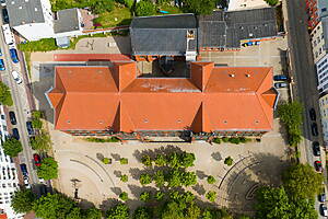 Der Schulkomplex der St.-Georg-Grundschule. Seit Ferienbeginn wird das Dach der Turnhalle für eine neue Dämmung vorbereitet.