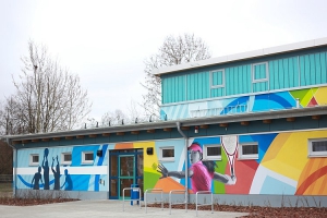Die Fassade zeigt die Vielfalt der sportlichen Aktivitäten in der Sporthalle. 